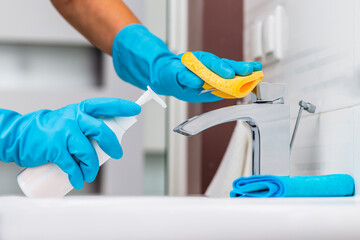 Cleaning sink and faucet with detergent.Coronavirus prevention, hygiene to stop spreading coronavirus.