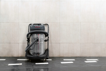 Commercial hoover next to the wall at car wash. Copy space for text. Commercial vacuum cleaner,...
