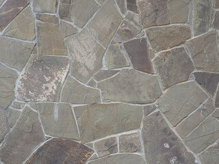 Wall clad with pieces of granite tiles of different sizes and shapes. Not seamless texture