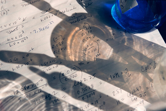 Shadow of laboratory beaker and tools on 16 papers