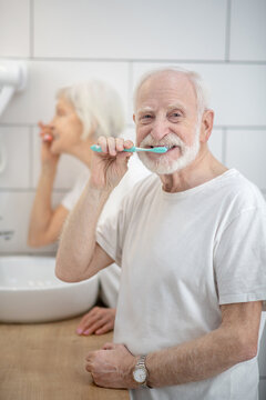 Senior Couple Brushing Their Teeth Together In The Bathroom