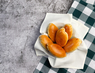 Small pie with green onions and eggs on a dark grey background. Top view, flat lay