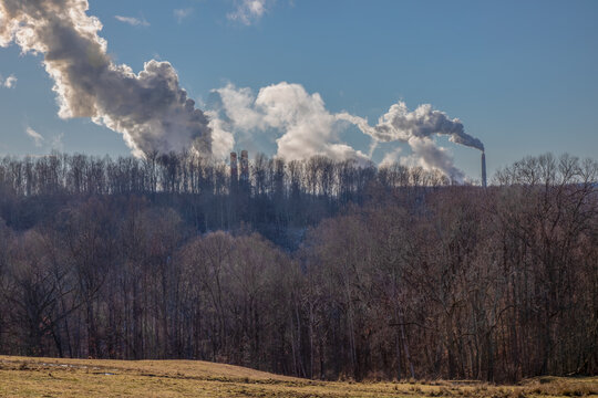 Smokestack emissions from coal fired powerplants photographed against a rural West Virginia backdrop