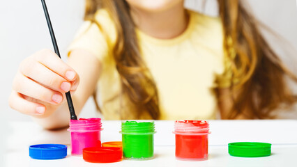 girl painting picture on white paper with Gouache Paint. unrecognizable