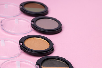 Obraz na płótnie Canvas Set of eyeshadows make up products on pink