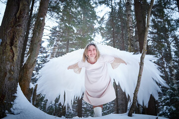 Fairy angel in the forest with snow and snowdrifts on a winter day