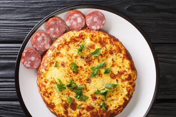 LuxembourgTierteg mashed potato pancakes with bacon and sauerkraut, served with sausages close-up in a plate on the table. Horizontal top view from above
