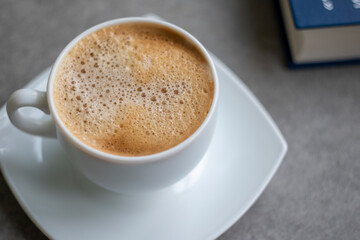 Cup of Morning cappuccino coffee with milk and blue book photography