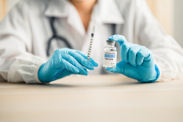 doctors or scientists show the coronavirus vaccine (COVID-19) and a syringe in laboratory room, concept for research and development of a vaccine against pathogens.