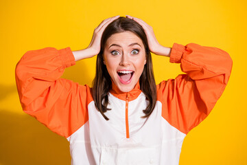 Photo of brunette cheerful young lady hold hands head amazed fan athlete wear orange jacket...