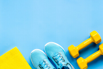 Flat lay of sport fitness equipments with sneakers and dumbbells