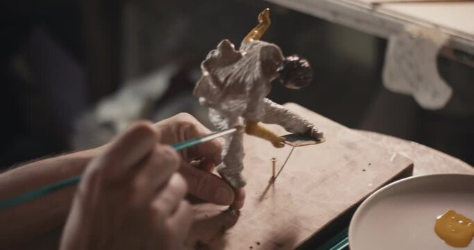 Artist paint skateboarder art sculpture hand with paintbrush close up