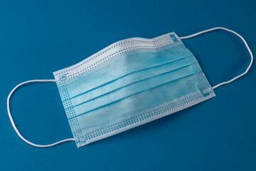 Close-up on surgical face mask on blue background