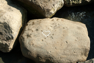 Chalk heart on sea rock