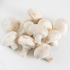 White Champignon mushrooms is a small edible mushroom with a light brown lid that grows in short grass, used for cooking. Isolated on white background.