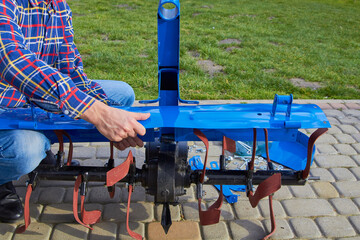 assembling a cultivator on a tractor,the farmer assembles a new cultivator for a two-wheeled tractor