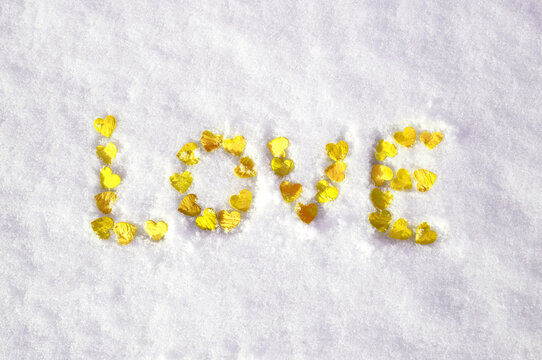 valentine's day concept: word love laid out with hearts on snow