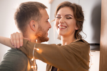 Portrait of beautiful young couple in casual clothes kissing and laughing