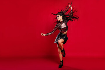 Full length photo of carefree girl dance wear glossy top glasses short skirt shoes isolated red...