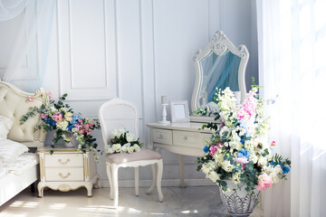 Fototapeta na wymiar Bright luxury white and blue colored interior living room with flowers in vases. the walls are decorated with baroque ornaments