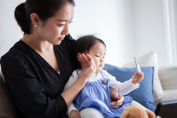 娘の発熱を気にする母親