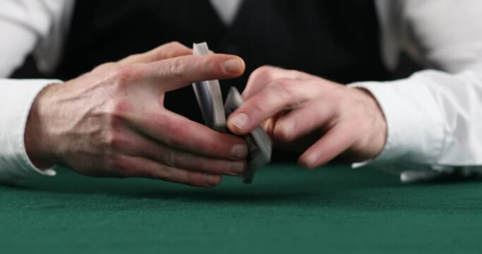 Casino, poker: Dealer shuffles the poker cards, shows on green table at casino, Dealer man shuffles the poker cards