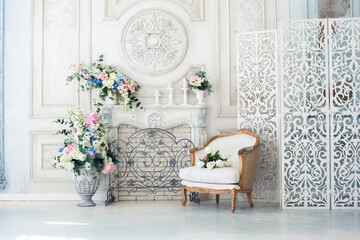 Bright luxury white and blue colored interior living room with flowers in vases. the walls are decorated with baroque ornaments - obrazy, fototapety, plakaty