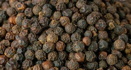 Black pepper grains as background close up.