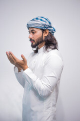 Religious muslim man praying on grey background