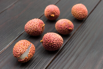 Lychee berries on dark wooden background