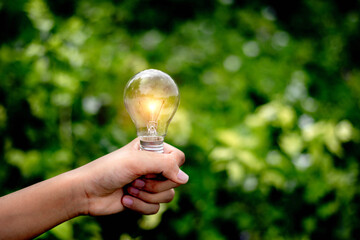 Hand holding light bulb,natural energy and love the world concept.
