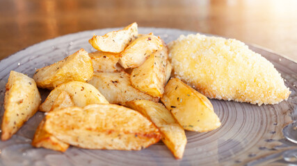 Baked potatoes with herbs and cutlets in breading with cheese and butter. Food on a plate in a cafe. Breakfast, lunch, dinner at the restaurant. Snack