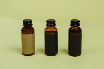 three different colored 35 ml bottles for cosmetics, on a colored background, place a logo