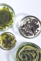 Different types of algae on a white background. Nori, wakame and dried kelp leaf. Micronutrient-rich Asian food ingredients, superfood, close-up