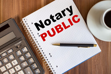 NOTARY PUBLIC written in a white notepad near a calculator and a cup of coffee on a dark wooden background