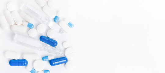 Pharmaceuticals, antibiotics, tablets, medicines. White and blue antibacterial pills on a light background. Capsules, tablets, medicines