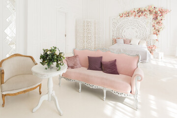 luxury delicate interior of the living room and bedroom in light colors with expensive chic carved furniture in classic style