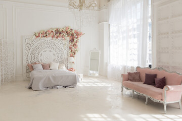 luxury delicate interior of the living room and bedroom in light colors with expensive chic carved furniture in classic style