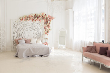 luxury delicate interior of the living room and bedroom in light colors with expensive chic carved furniture in classic style