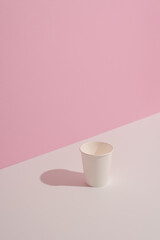Trending colors. Design of white cup on white table on pink background. Copy space
