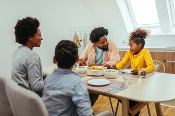 Cute afro family having lunch together at home
