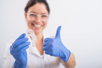 The orthodontist holds the removable transparent retainers