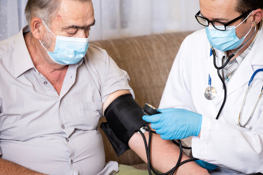 Doctor measuring blood pressure of male patient