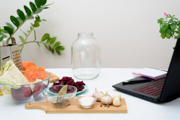 Cook at home online video recipes on a laptop Pickled pink cabbage fermentative with beets and carrots in brine in a jar