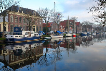 Reflections of historic houses and boats along Nieuwe Haven street, Edam, North Holland, Netherlands