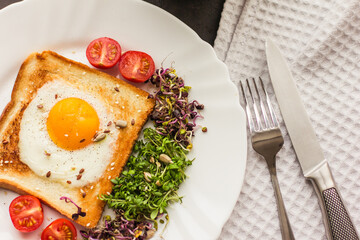 Sandwich with scrambled eggs, tomatoes, sprouts of arugula and radishes, micro-greens Healthy food