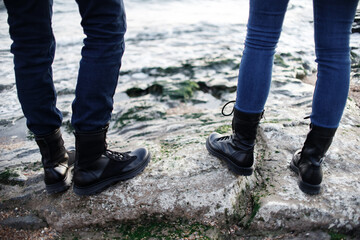 Man and woman in black boots are resting in the mountains