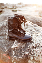 Army black boots for men on laces for outdoor activities stand on a background of stone