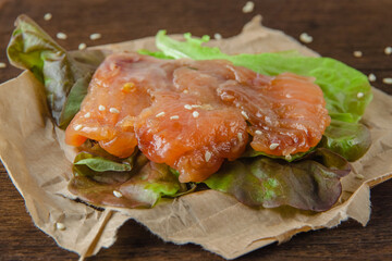 Open sandwich with red fish trout and salad on a wooden board