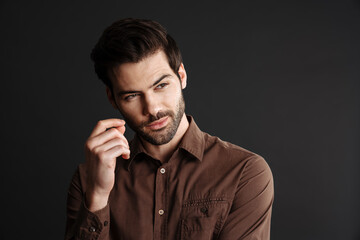 Brunette handsome unshaven guy posing and looking aside